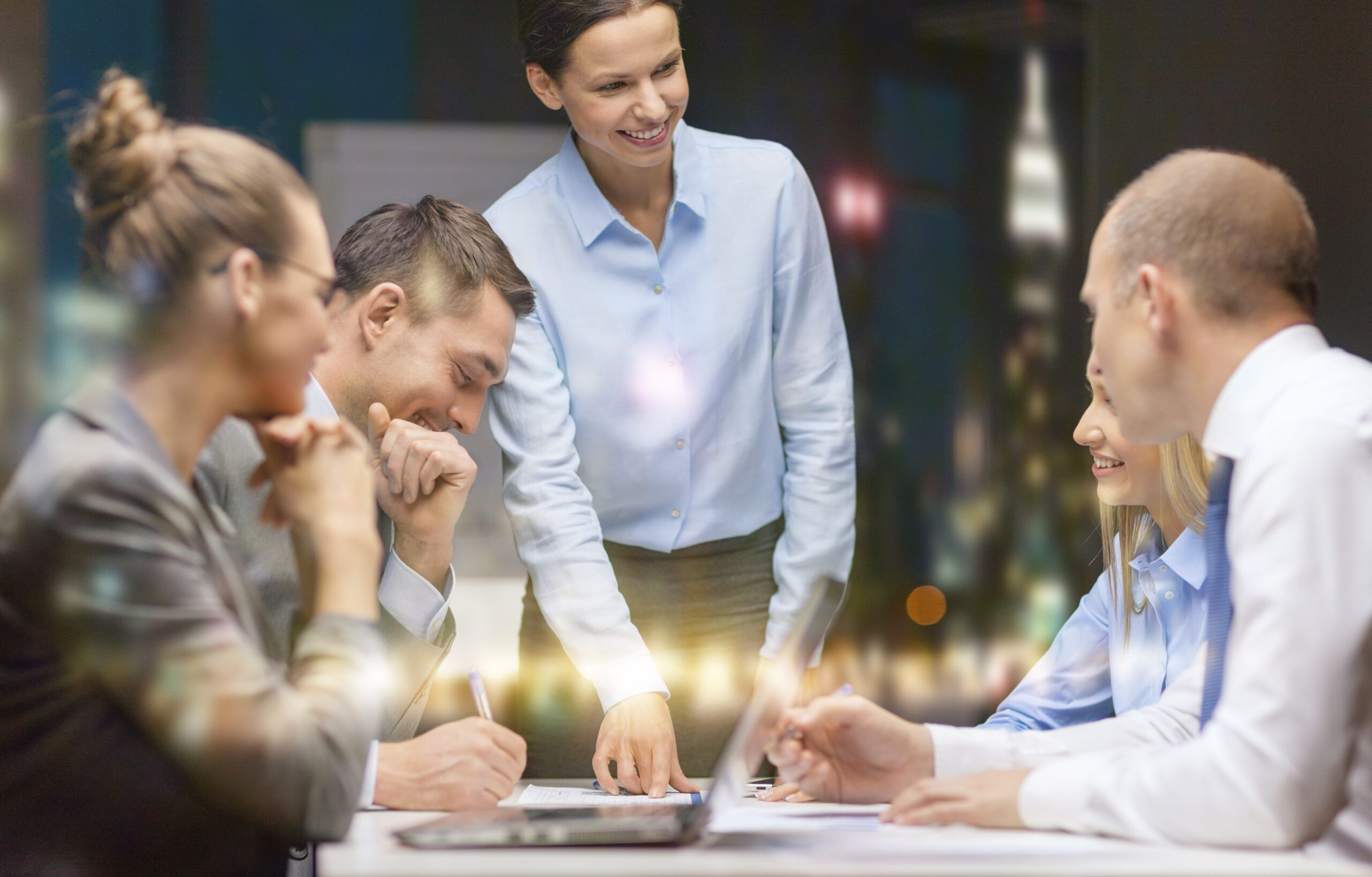 smiling female boss talking to business team